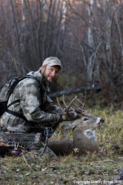 Bowhunter with bagged whitetail buck.