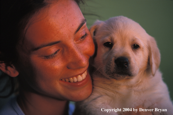 Woman with yellow Labrador Retriever puppy