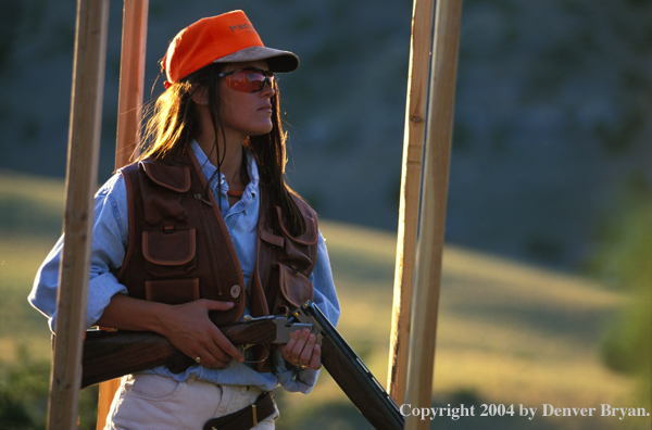 Woman with shotgun at shooting range.