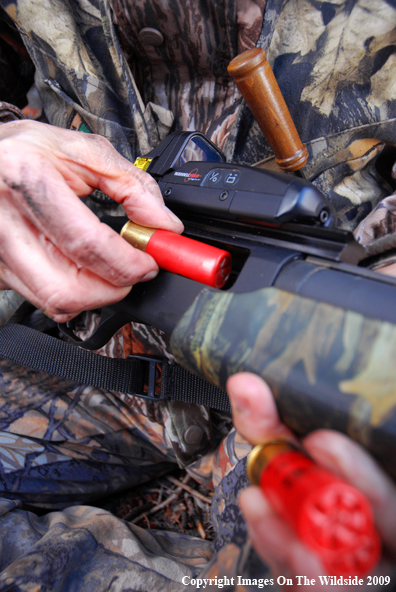 Hunter loading shotgun shells.