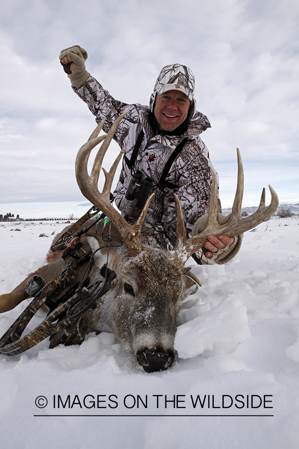 Bowhunter with bagged white-tailed deer.
