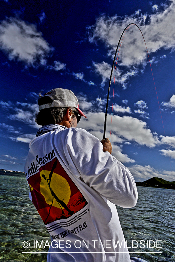 Saltwater flyfisherman fishing on flats boat, in Hawaii. (HDR)