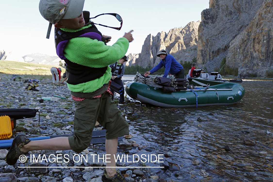 Young boy skipping rocks on the river.