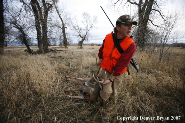 Hunter in field with bagged deer