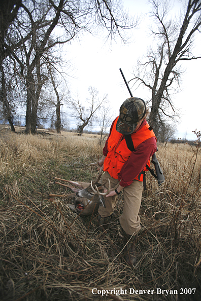 Hunter in field with bagged deer