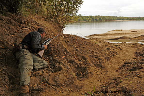 Hunter sneaking up on African crocodile