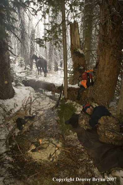 Hunter resting by campfire
