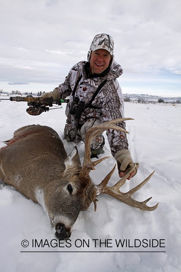 Bowhunter with bagged white-tailed deer.