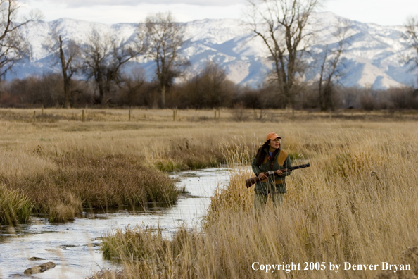 Woman hunter in field.