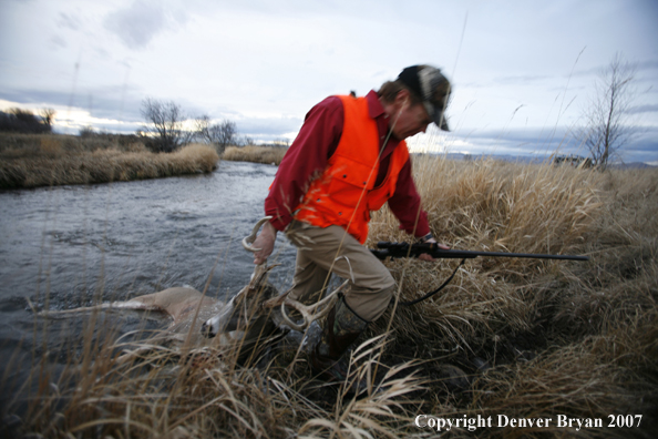 Hunter in field with bagged deer