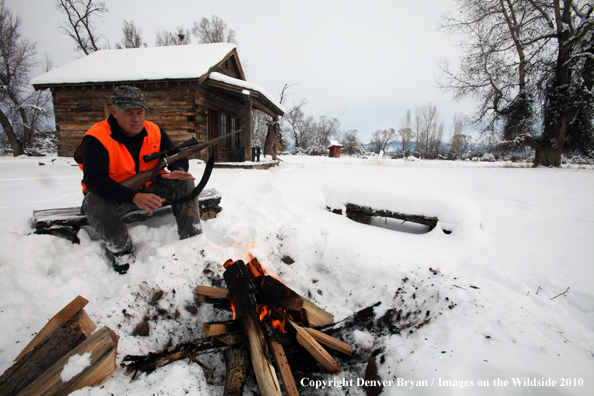White-tailed deer hunter harming hands by campfire