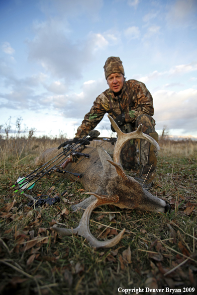 Bowhunter with whitetail buck.