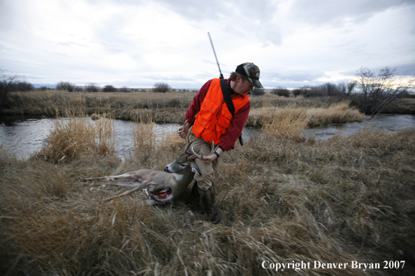 Hunter in field with bagged deer