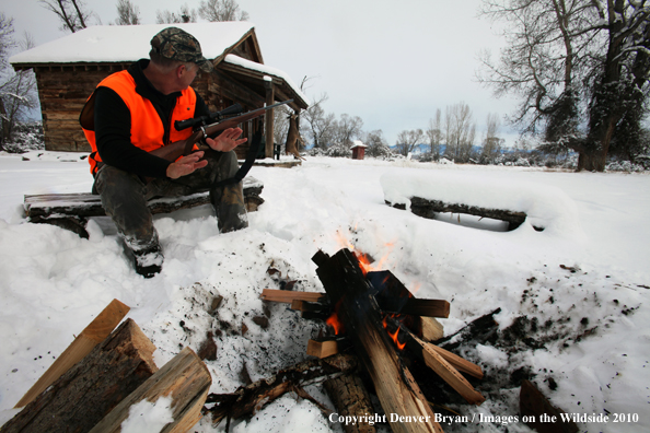 White-tailed deer hunter harming hands by campfire