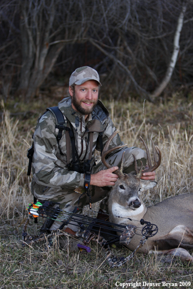 Bowhunter with bagged whitetail buck.