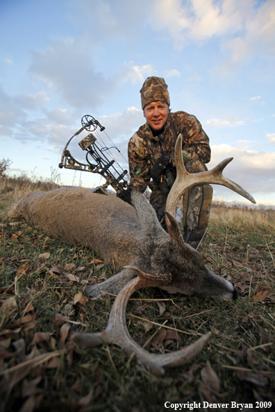 Bowhunter with whitetail buck.