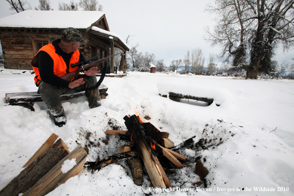 White-tailed deer hunter harming hands by campfire