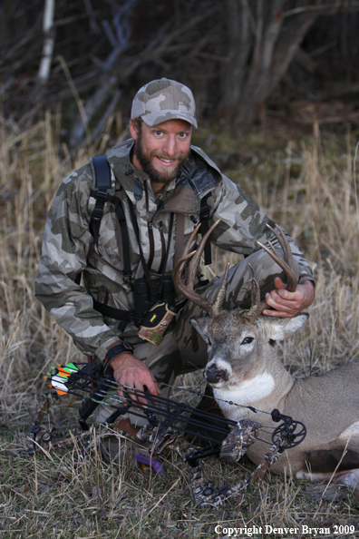 Bowhunter with bagged whitetail buck.