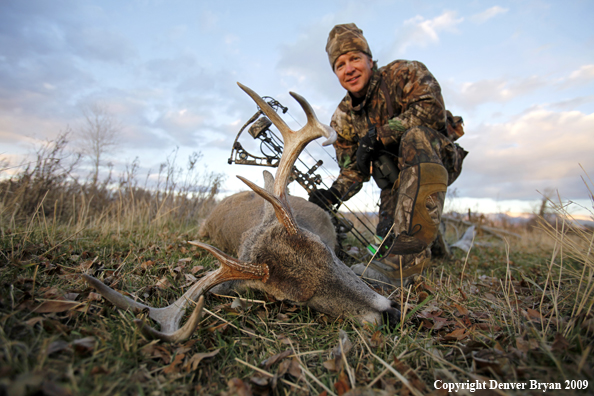 Bowhunter with whitetail buck.