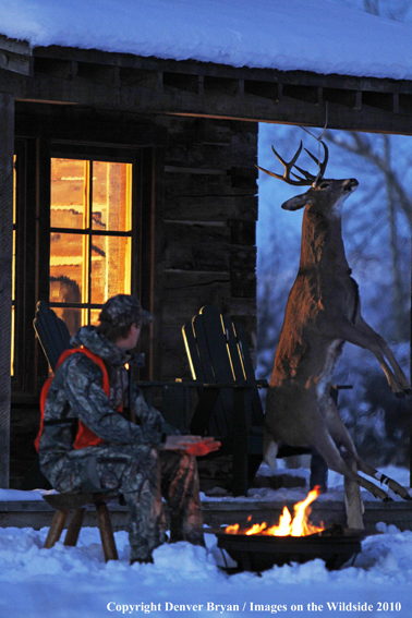 White-tailed deer hunter warming hands by campfire