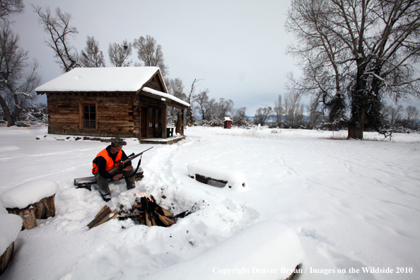 White-tailed deer hunter harming hands by campfire