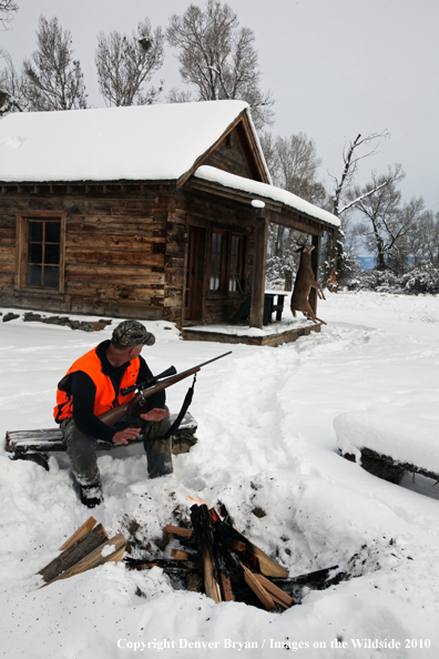 White-tailed deer hunter harming hands by campfire