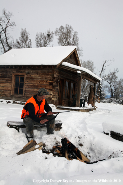 White-tailed deer hunter harming hands by campfire