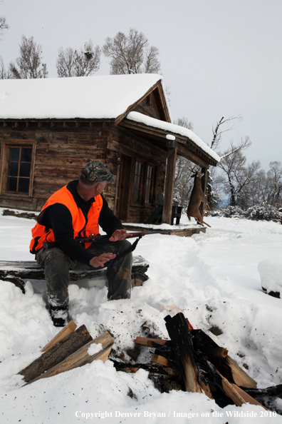 White-tailed deer hunter harming hands by campfire