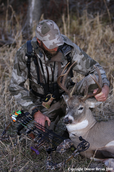 Bowhunter with bagged whitetail buck.