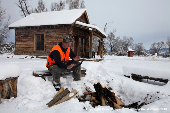 White-tailed deer hunter harming hands by campfire