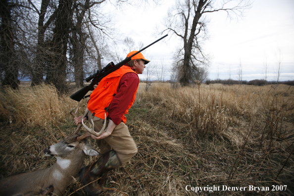 Hunter in field with bagged deer