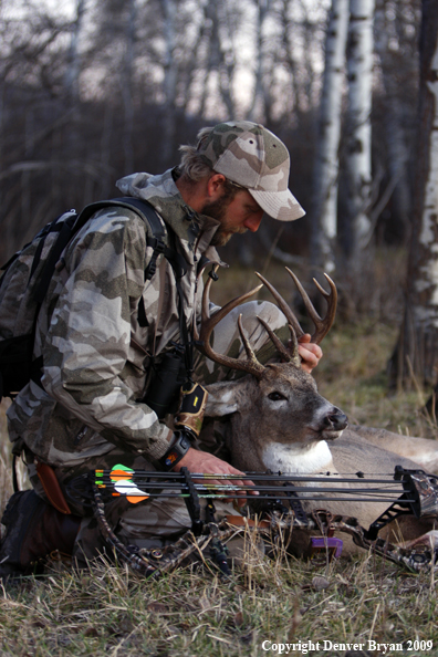 Bowhunter with bagged whitetail buck.