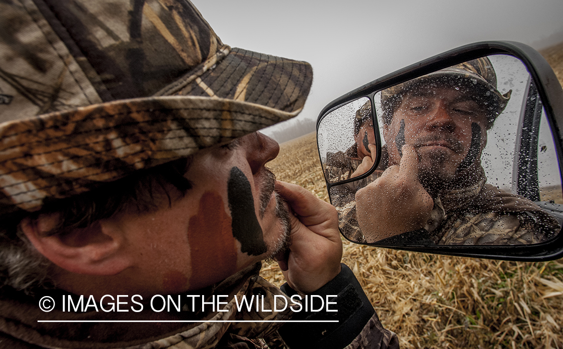 Bowhunter applying camouflage. 