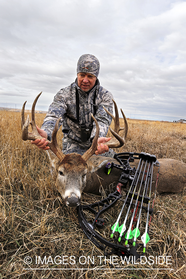 Bowhunter with downed white-tailed buck.