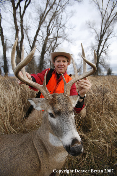 Hunter in field with bagged deer