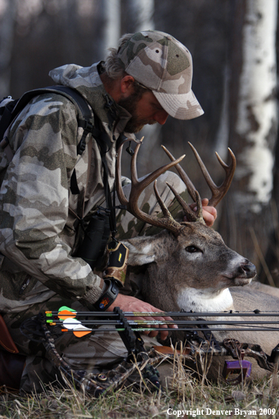 Bowhunter with bagged whitetail buck.