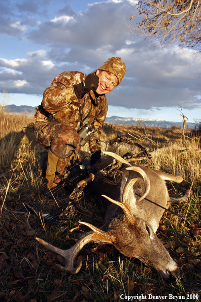 Bowhunter with whitetail buck kill.
