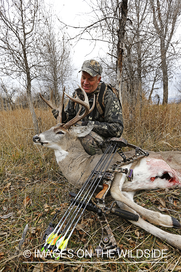 Bowhunter with bagged white-tailed buck.