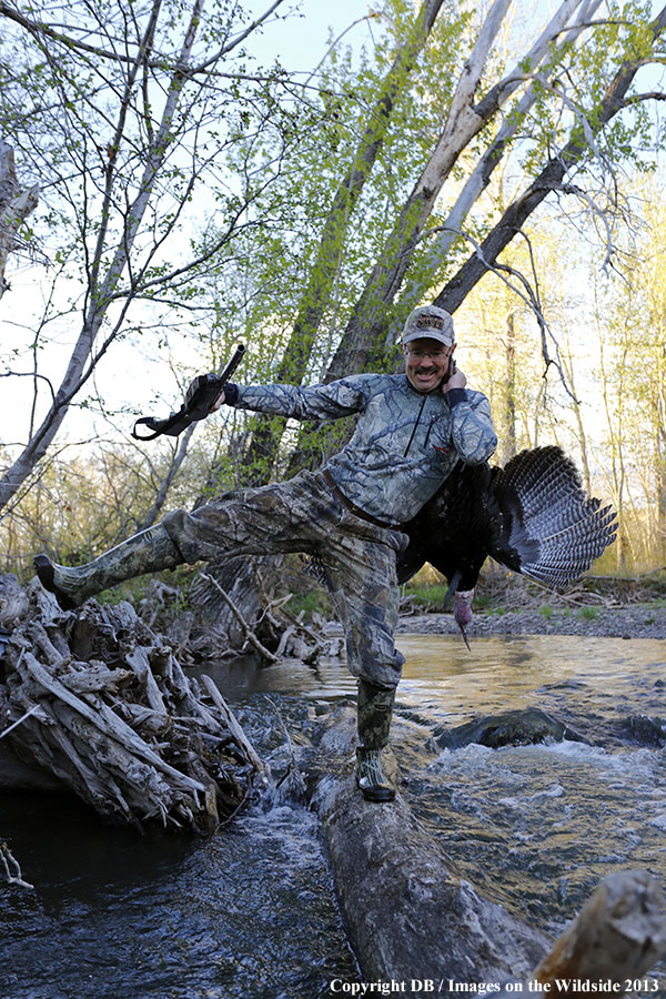 Turkey hunter in field with bagged turkey.