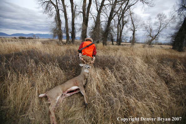 Hunter in field with bagged deer