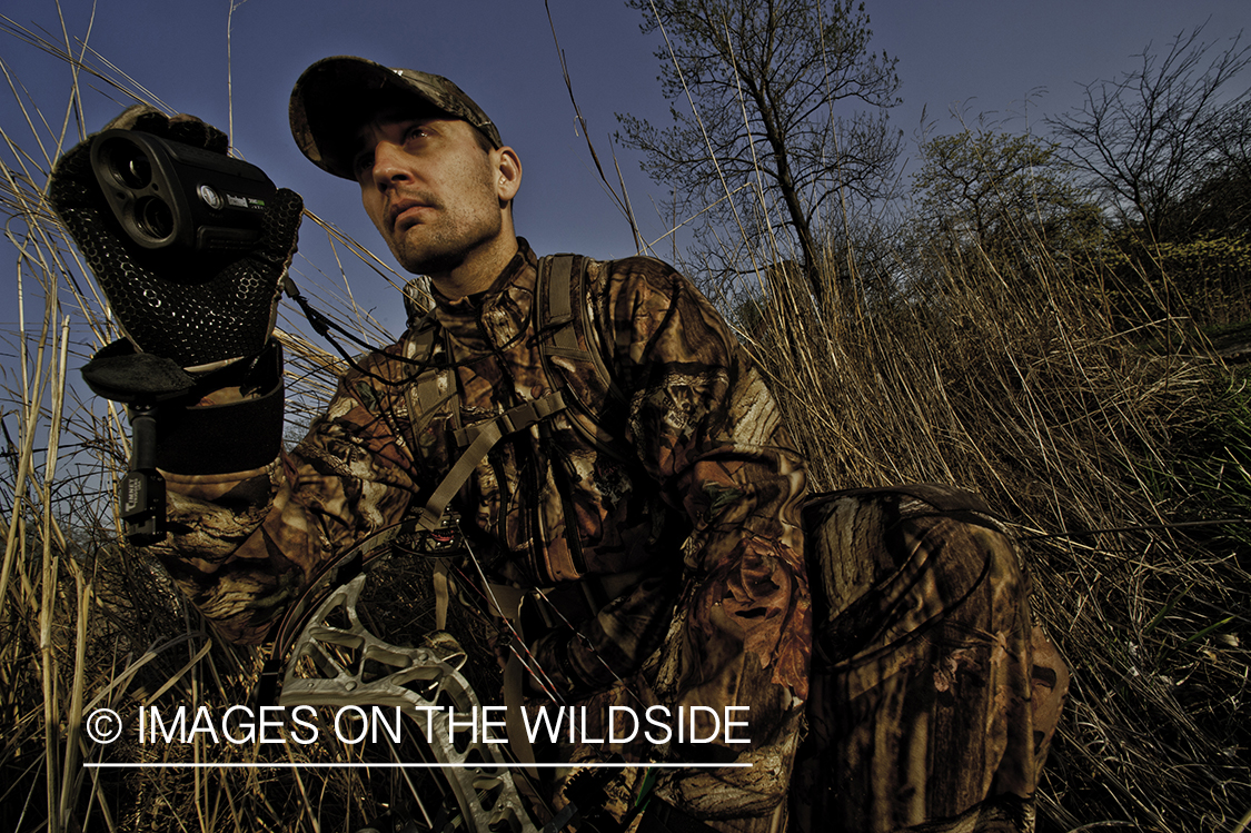 Bowhunter using rangefinder. 