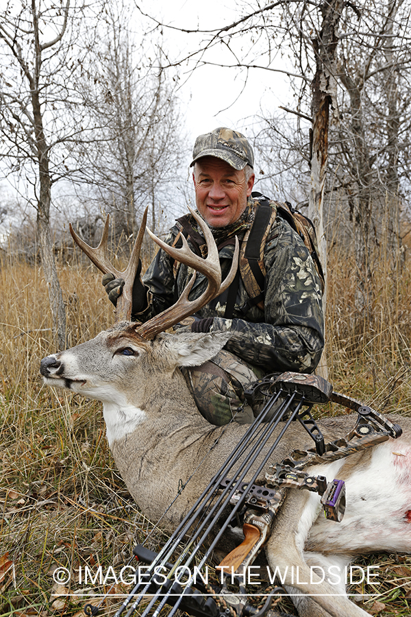 Bowhunter with bagged white-tailed buck.
