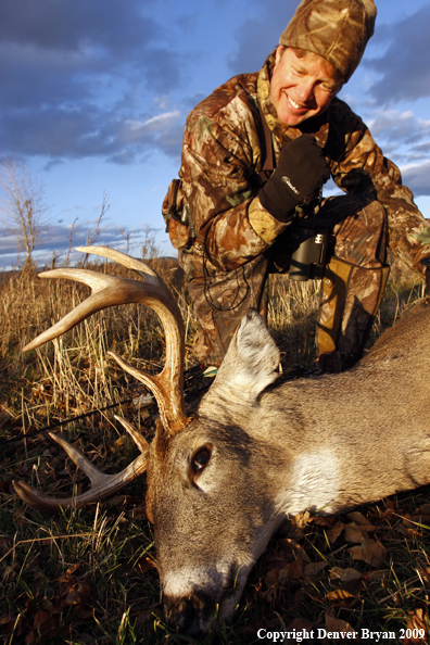 Bowhunter with whitetail buck kill.