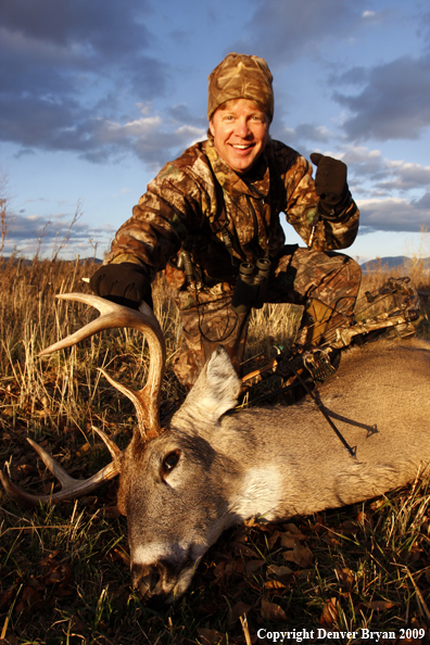 Bowhunter with whitetail buck kill.