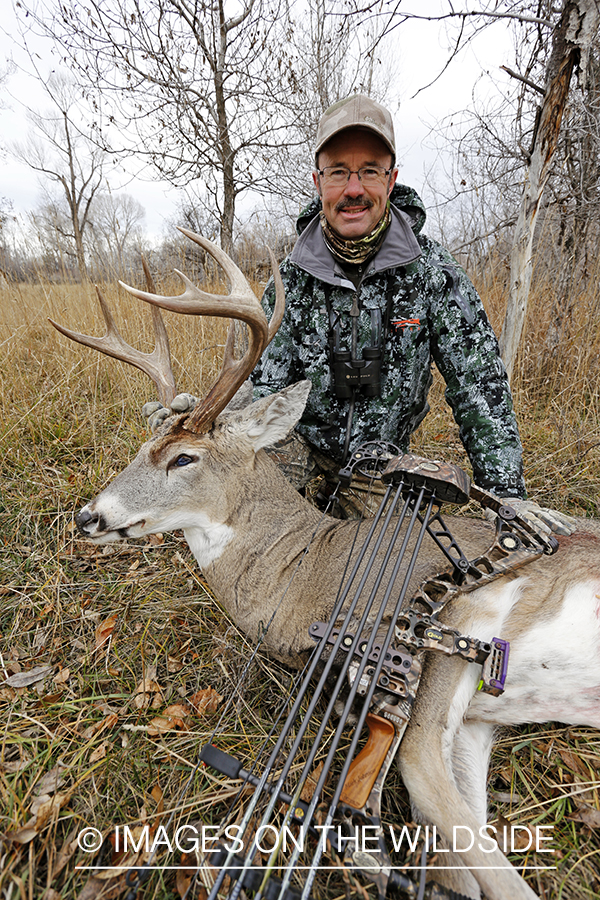 Bowhunter with bagged white-tailed buck.