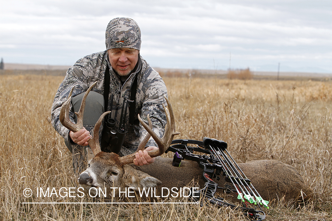 Bowhunter with downed white-tailed buck.