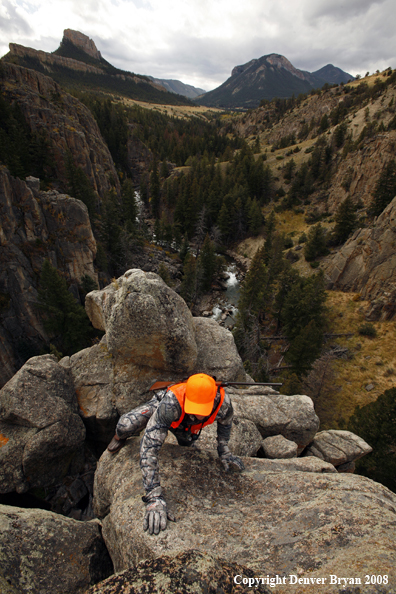 Rifle hunter climbing rocks