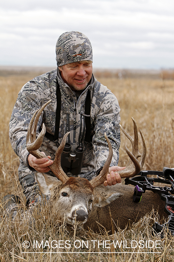 Bowhunter with downed white-tailed buck.