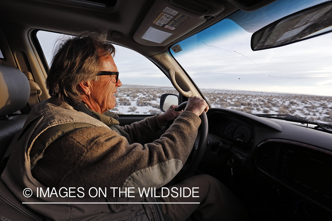 Falconer driving through field.