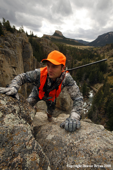 Rifle hunter climbing rocks